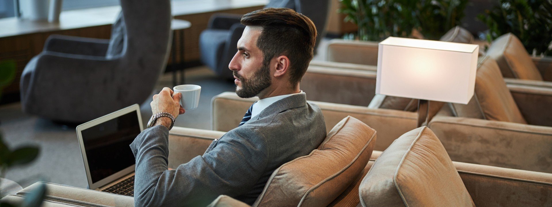 man holding laptop and coffee cup