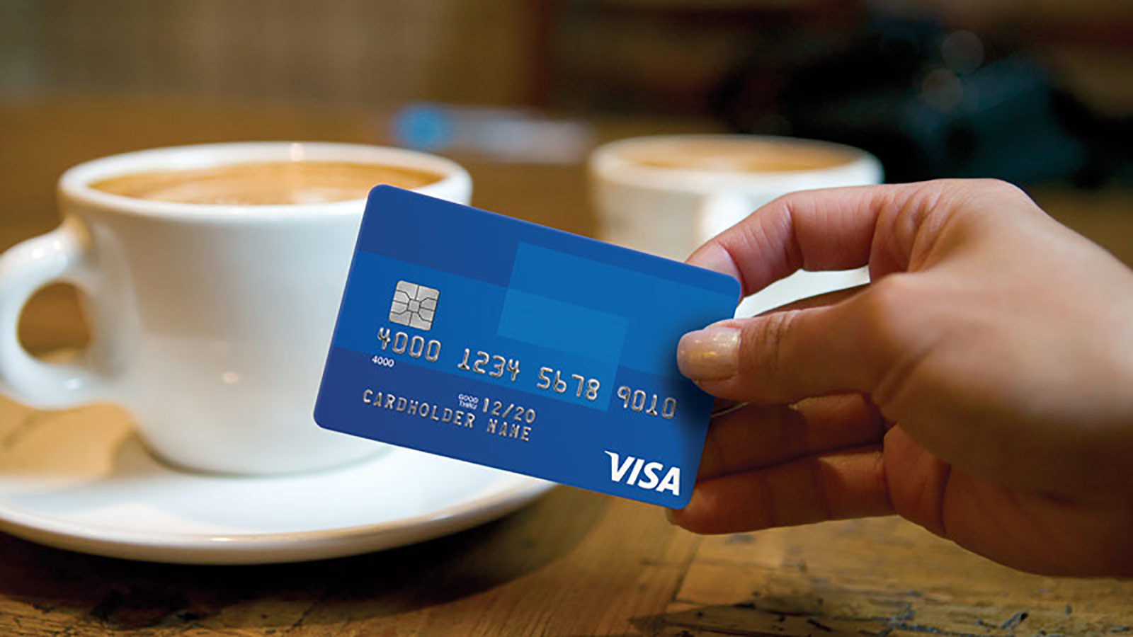 two coffees and woman holding credit card