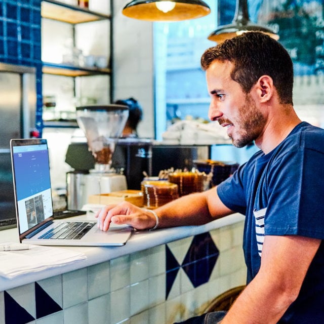 Man working on laptop in coffee shop