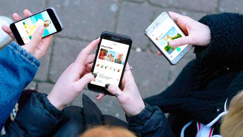 three people using mobiles